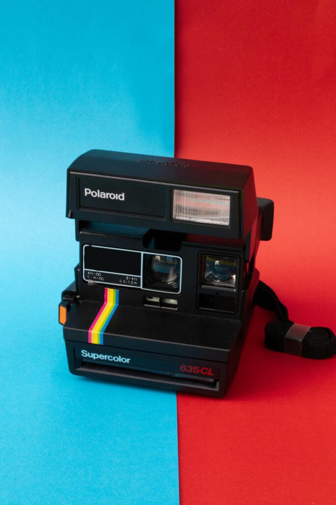 Retro Polaroid 635 CL camera on red and blue split background, studio shot.